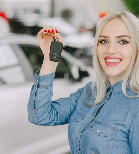 Lady in a car salon. Woman buying the car. Elegant woman in a blue dress.
